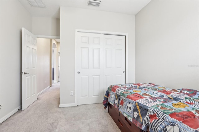 bedroom featuring light colored carpet and a closet