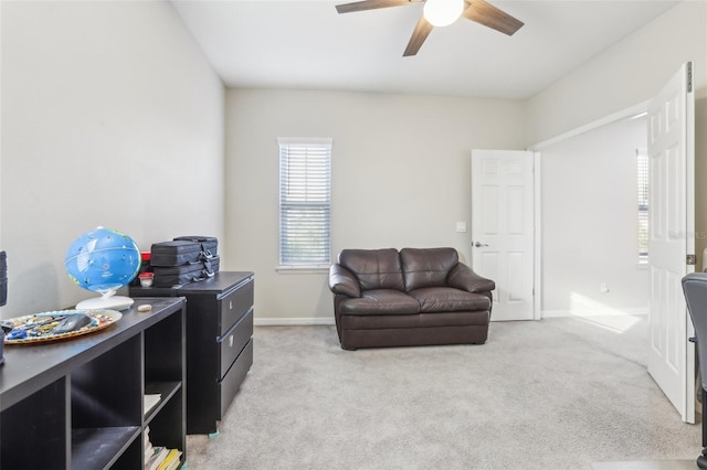 living area featuring light carpet and ceiling fan