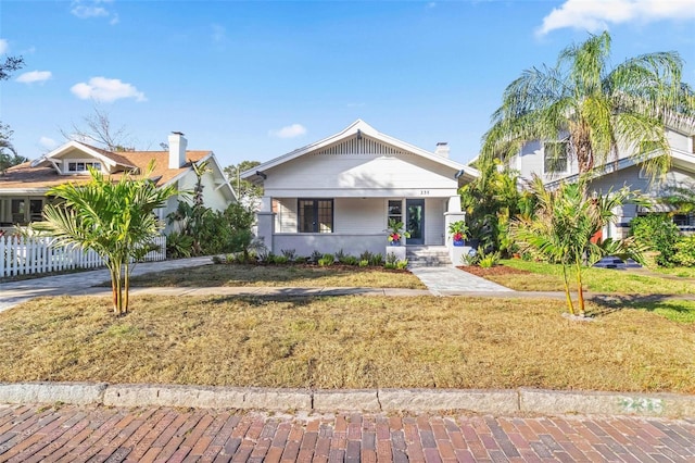 view of front of house with covered porch and a front yard