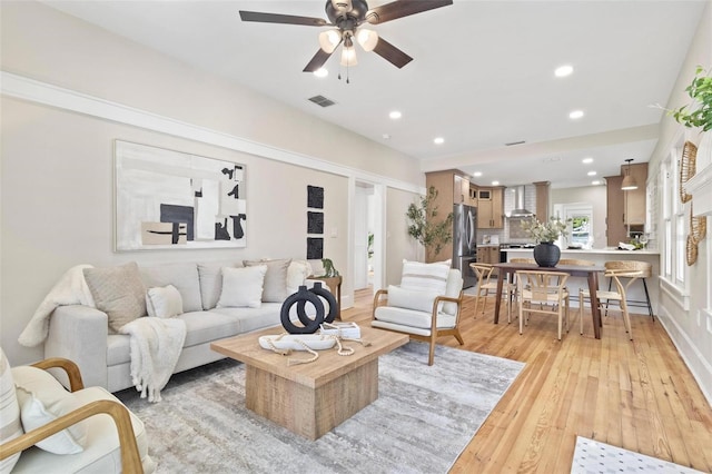 living room featuring ceiling fan and light wood-type flooring