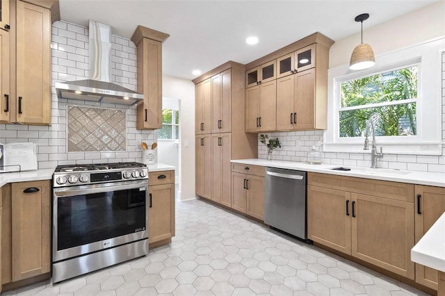 kitchen with appliances with stainless steel finishes, decorative light fixtures, sink, backsplash, and wall chimney exhaust hood