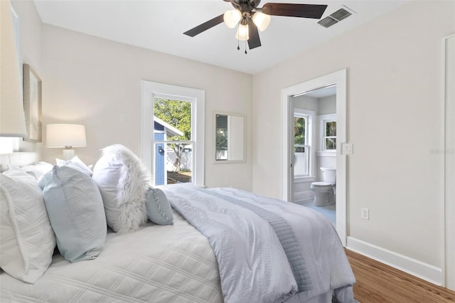 bedroom with hardwood / wood-style floors, connected bathroom, and ceiling fan