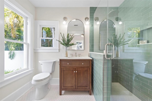 bathroom with an enclosed shower, vanity, tile patterned floors, and toilet