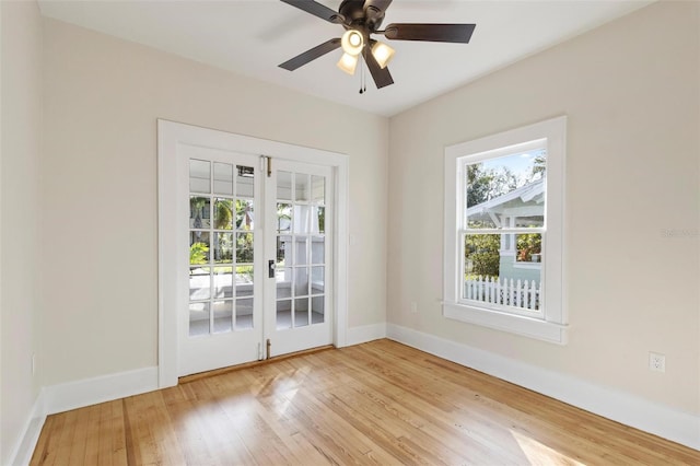 empty room featuring ceiling fan, light wood-type flooring, and french doors