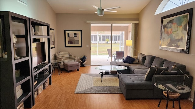 living room with light hardwood / wood-style flooring and ceiling fan