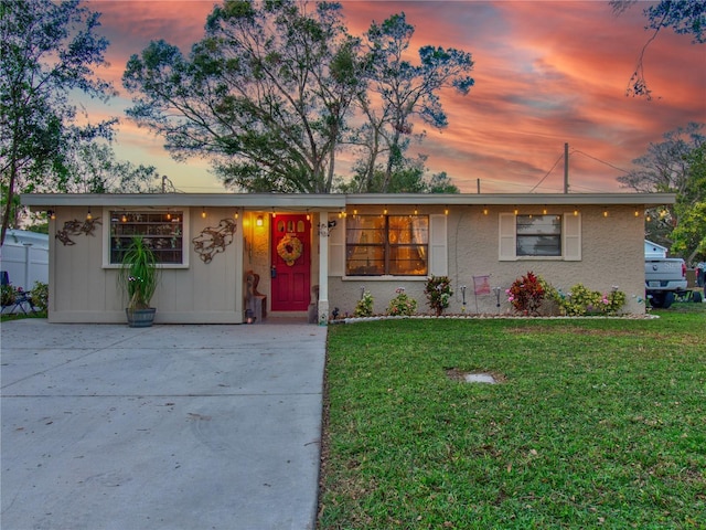 ranch-style home featuring a lawn