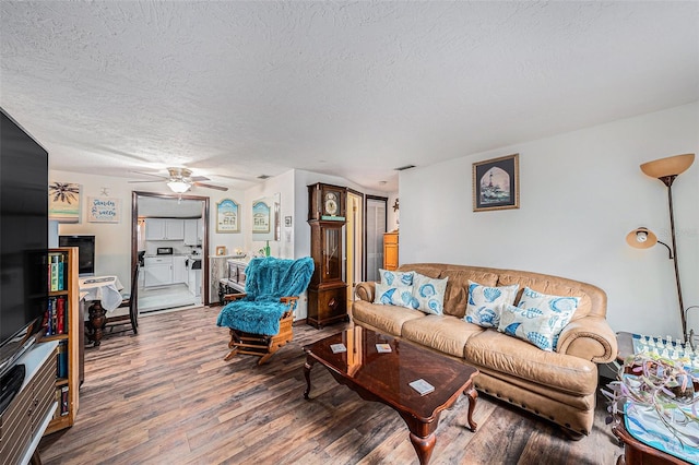 living room with hardwood / wood-style floors, a textured ceiling, and ceiling fan