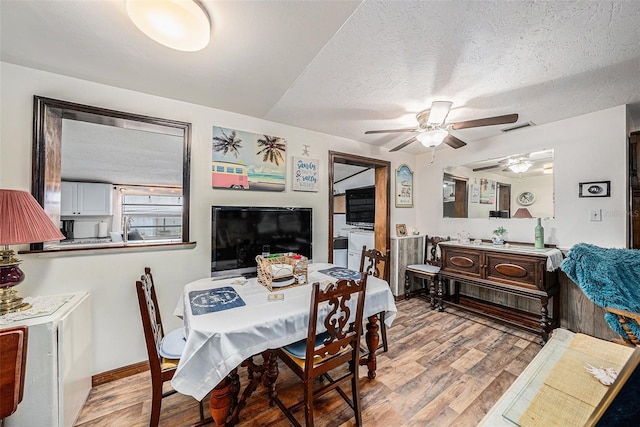 dining room with ceiling fan, a textured ceiling, and light hardwood / wood-style floors