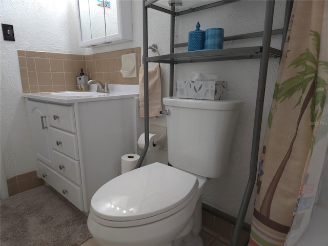 bathroom featuring tasteful backsplash, vanity, a shower with shower curtain, and toilet