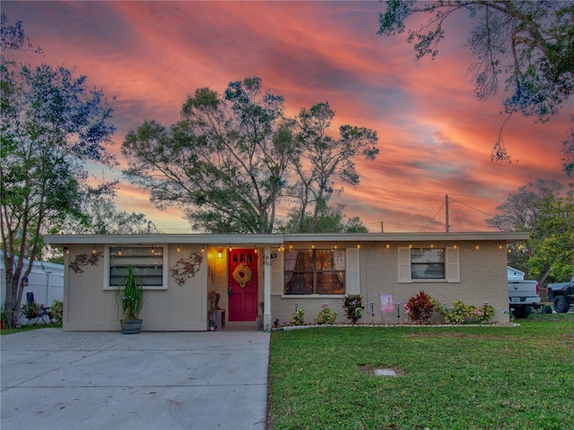 single story home featuring a lawn