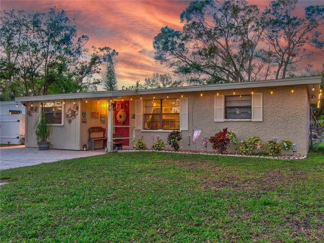 ranch-style home with a lawn