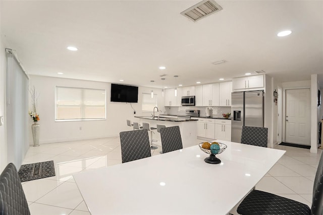 dining area with light tile patterned flooring and sink