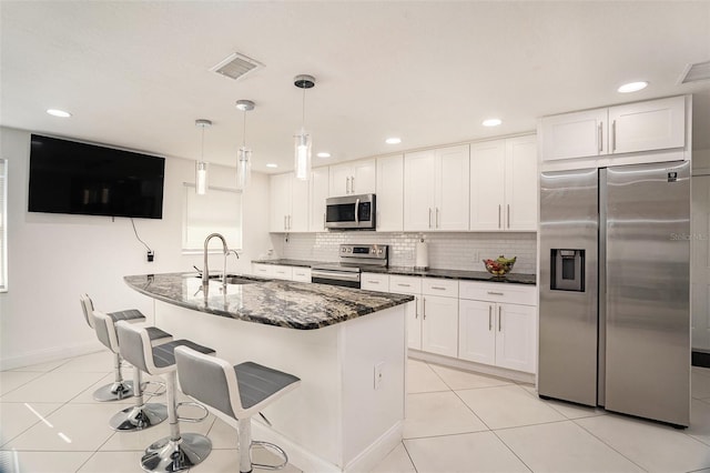 kitchen featuring pendant lighting, white cabinetry, appliances with stainless steel finishes, and sink