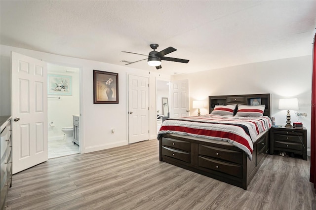 bedroom featuring ensuite bathroom, hardwood / wood-style floors, a textured ceiling, and ceiling fan