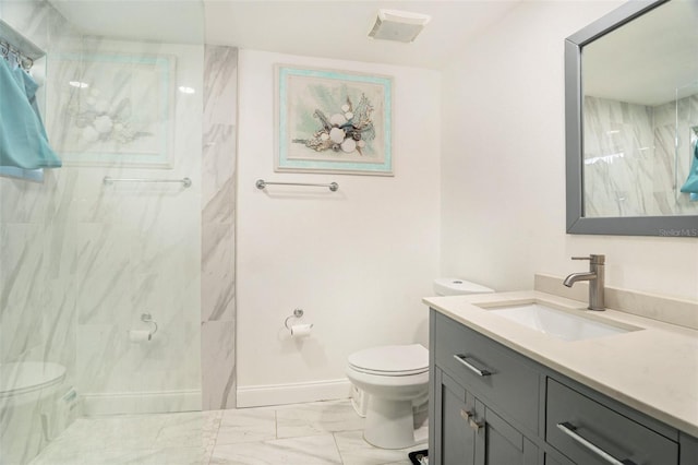 bathroom featuring vanity, toilet, and tiled shower