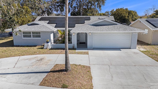 view of front of home featuring a garage and solar panels