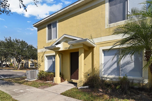 view of exterior entry featuring a garage and central AC unit