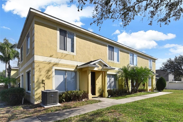 view of property featuring central AC and a front yard