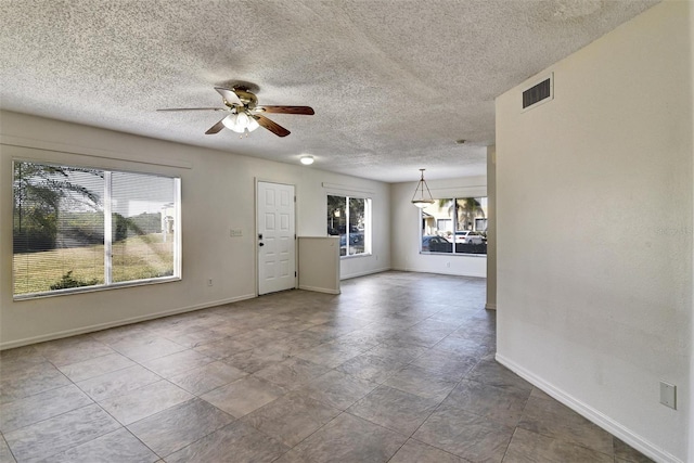 unfurnished living room with a textured ceiling and ceiling fan