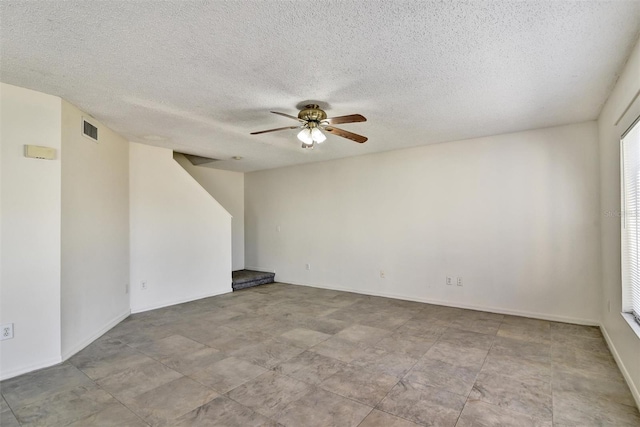 spare room with a textured ceiling and ceiling fan