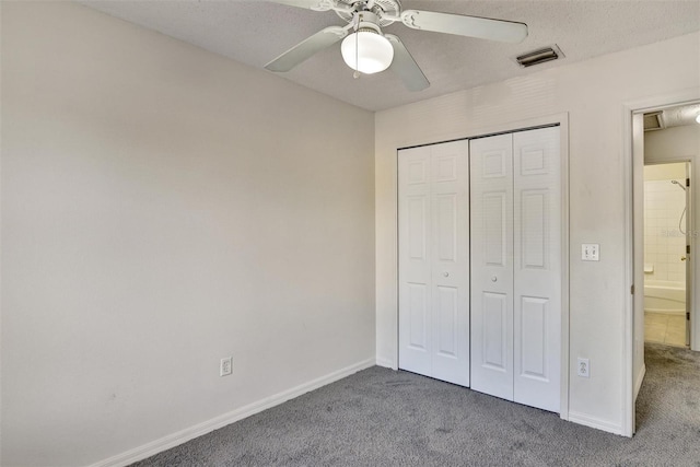 unfurnished bedroom featuring ceiling fan, carpet floors, a closet, and a textured ceiling