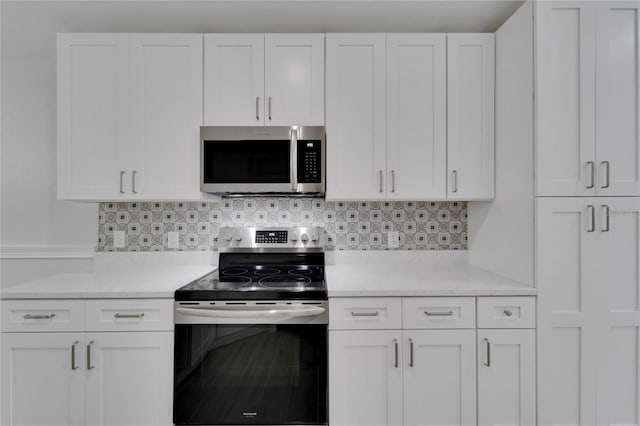 kitchen featuring appliances with stainless steel finishes, white cabinets, and decorative backsplash