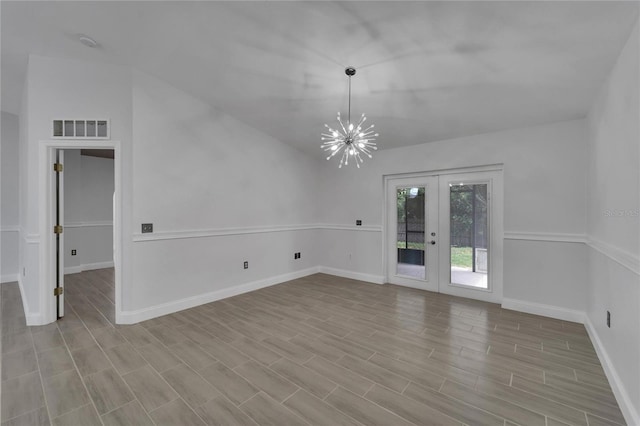 empty room featuring french doors and a notable chandelier