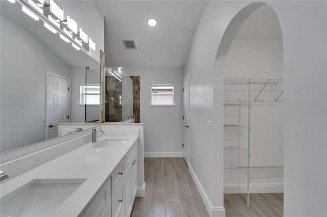 bathroom with lofted ceiling, vanity, and an enclosed shower