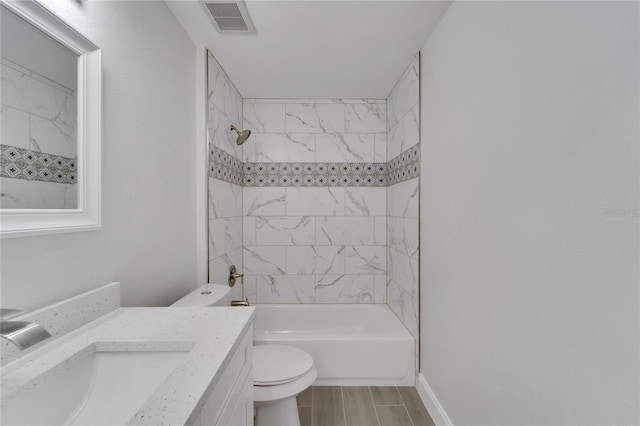 full bathroom featuring tiled shower / bath, vanity, and toilet