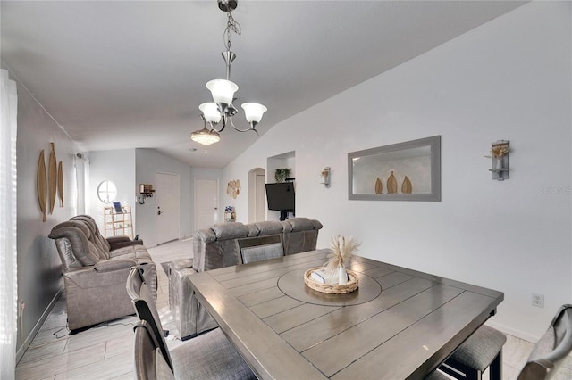 dining space with vaulted ceiling and an inviting chandelier