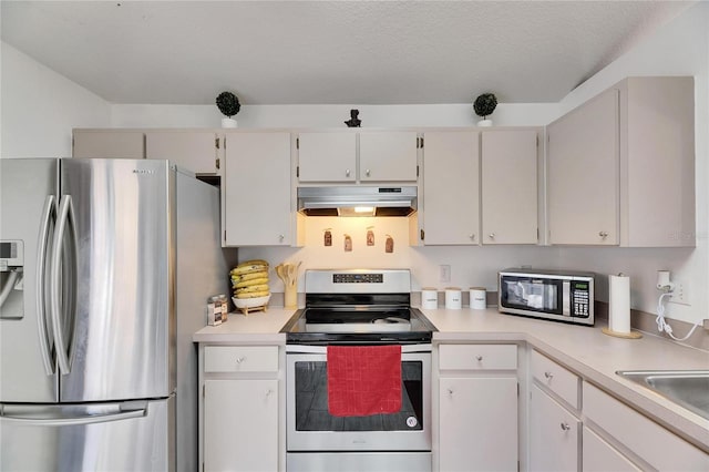 kitchen featuring white cabinetry, a textured ceiling, and appliances with stainless steel finishes