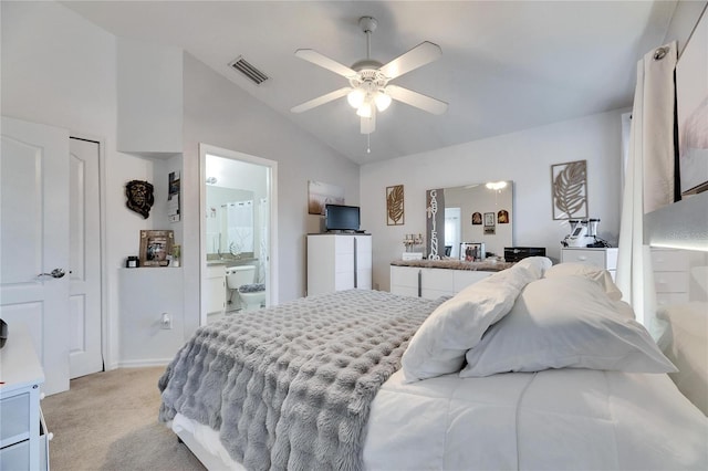 carpeted bedroom with ceiling fan, vaulted ceiling, and ensuite bath