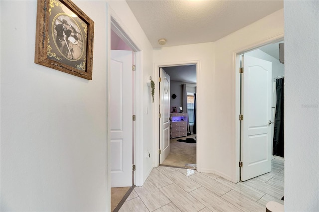 hallway with a textured ceiling