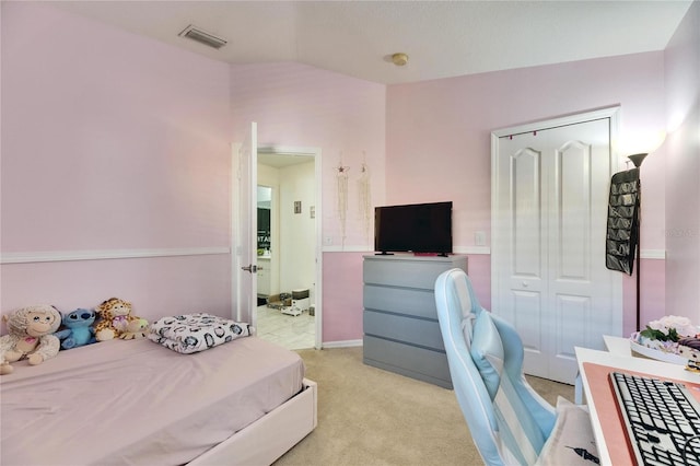 bedroom featuring lofted ceiling, light colored carpet, and a closet