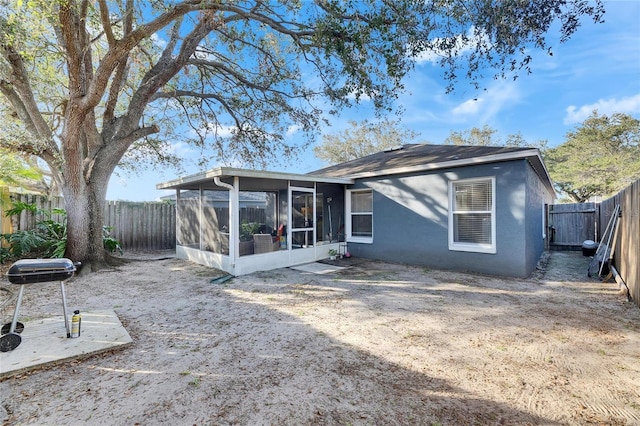 rear view of property featuring a sunroom