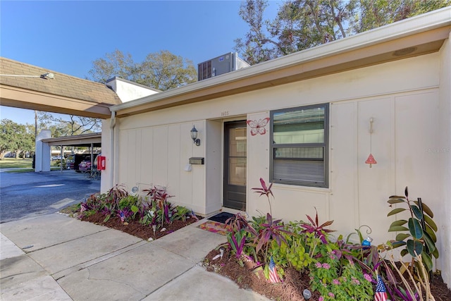 doorway to property with central AC and a carport