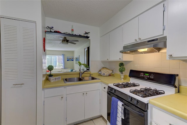 kitchen featuring sink, white gas stove, and white cabinets