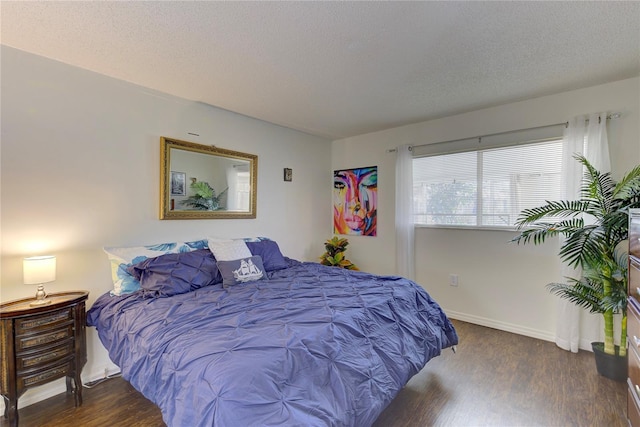 bedroom with dark hardwood / wood-style flooring and a textured ceiling