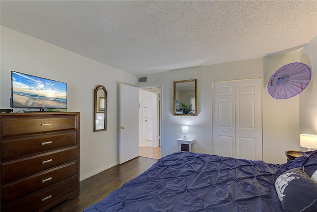 bedroom with dark hardwood / wood-style flooring and a textured ceiling