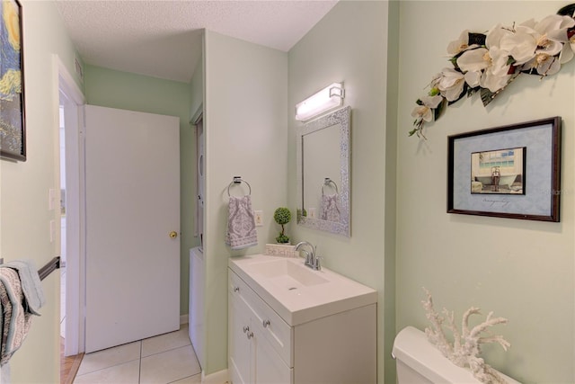 bathroom with vanity, tile patterned flooring, a textured ceiling, and toilet