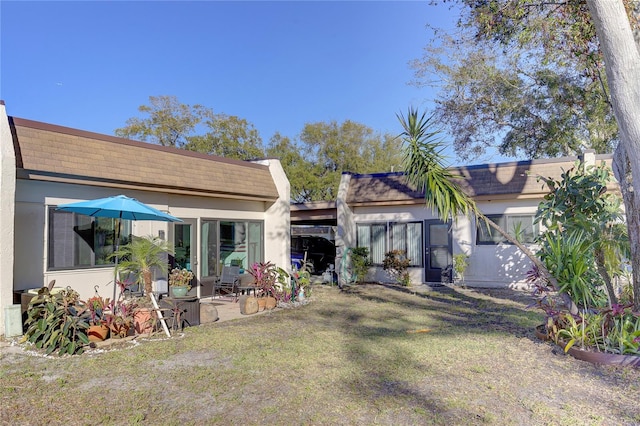 rear view of property featuring a lawn