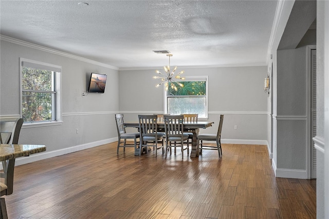 dining space featuring an inviting chandelier, crown molding, wood-type flooring, and a healthy amount of sunlight