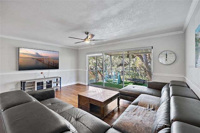 living room featuring ornamental molding, hardwood / wood-style floors, ceiling fan, and a textured ceiling