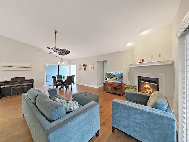 living room featuring lofted ceiling, a notable chandelier, and light hardwood / wood-style flooring