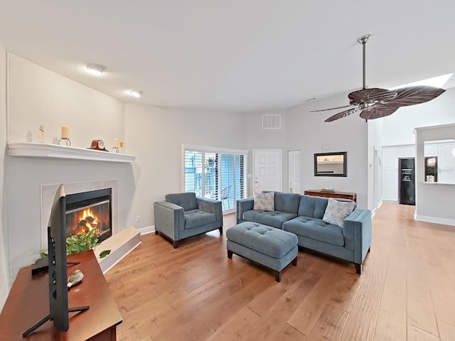 living room featuring hardwood / wood-style floors and ceiling fan