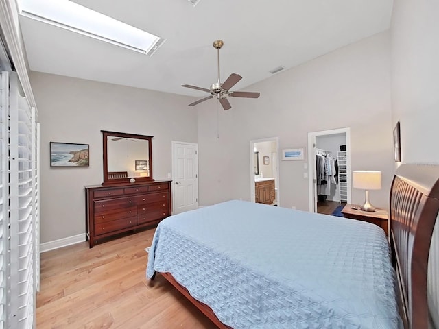 bedroom with a walk in closet, ensuite bath, a closet, ceiling fan, and light hardwood / wood-style floors