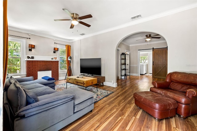 living room with hardwood / wood-style flooring, a barn door, plenty of natural light, and ceiling fan