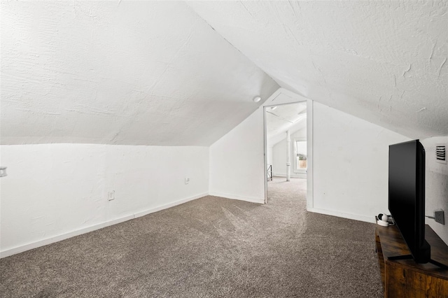 bonus room with lofted ceiling, carpet floors, and a textured ceiling