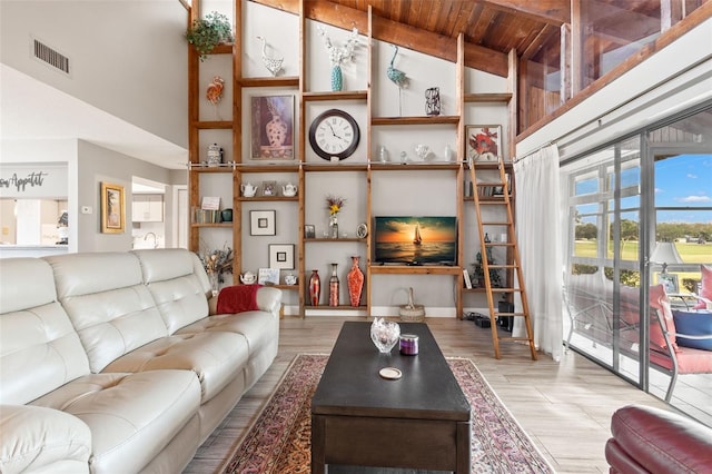 living room with a towering ceiling, wooden ceiling, and light wood-type flooring