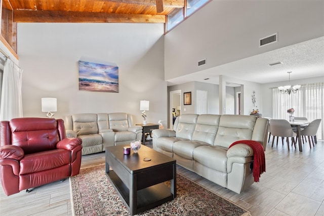 living room featuring wooden ceiling, a notable chandelier, and beam ceiling